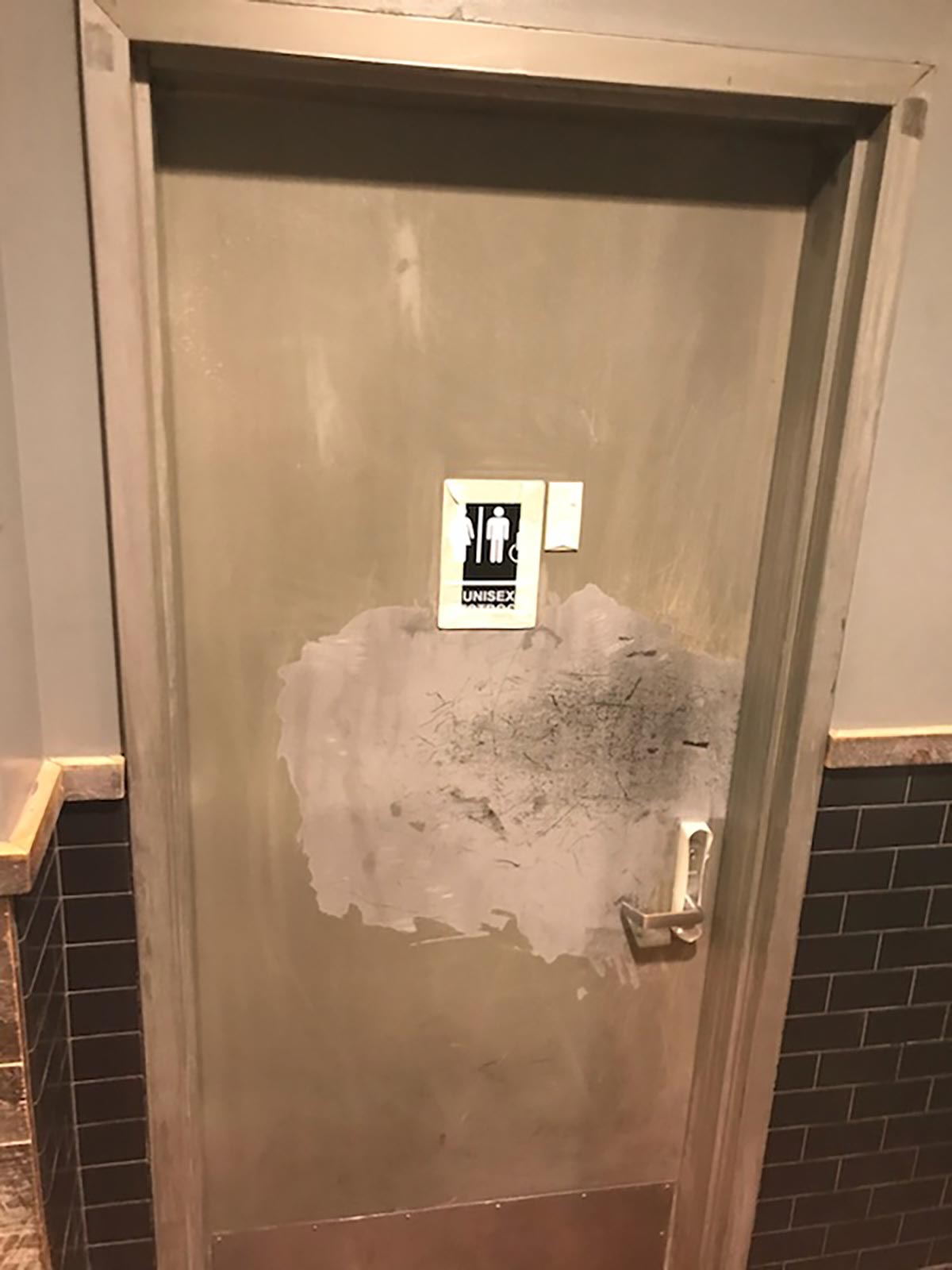 Bathroom door "before" door repair by our commercial painting contractors
